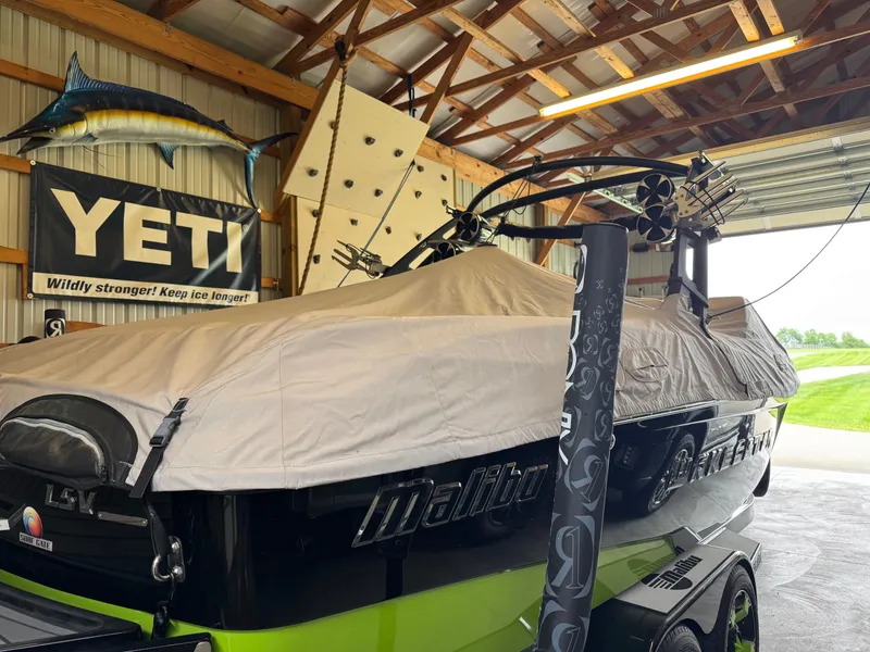 Slide: The Image of 2016 Malibu Wakesetter 23 LSV boat covered in a garage with Yeti banner. - 8