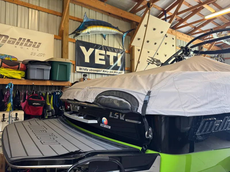 Slide: The Image of 2016 Malibu Wakesetter 23 LSV in garage with YETI banner and fishing decor. - 9