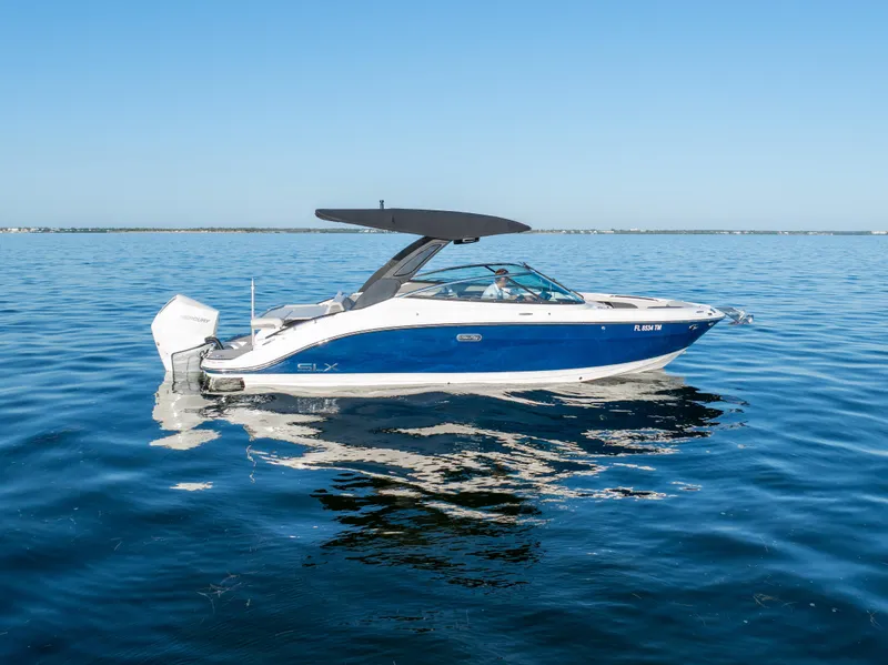 Slide: The Image of 2023 Sea Ray SLX 260 Outboard boat on calm blue water. - 16