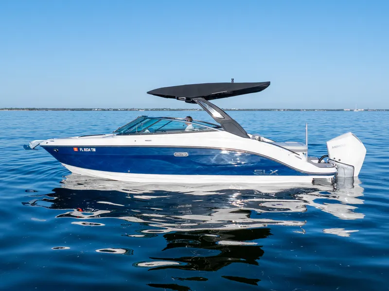 Slide: The Image of 2023 Sea Ray SLX 260 Outboard boat on calm blue water. - 20