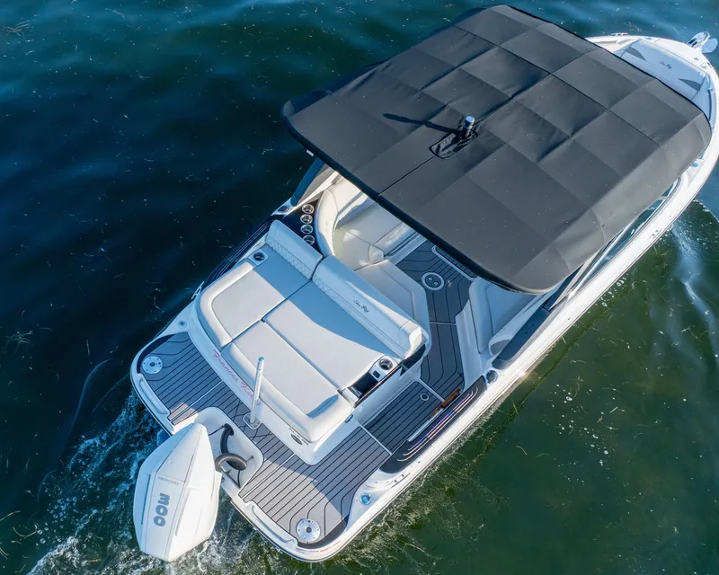 Slide: The Image of 2023 Sea Ray SLX 260 Outboard boat with black canopy cruising on water. - 22