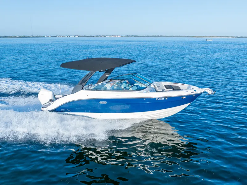 Slide: The Image of 2023 Sea Ray SLX 260 Outboard cruising on open water, featuring sleek blue and white design. - 31