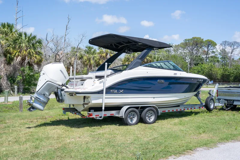 Slide: The Image of 2023 Sea Ray SLX 260 Outboard boat on trailer, parked on grass. - 4