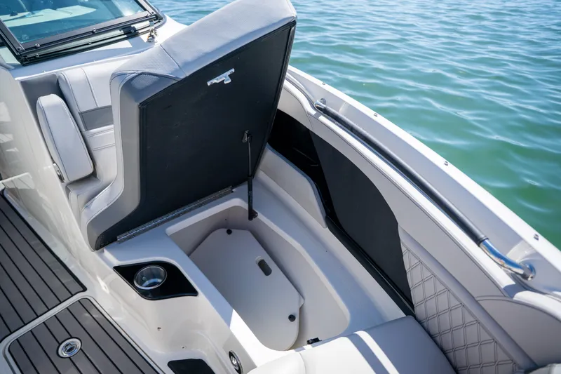Slide: The Image of 2023 Sea Ray SLX 260 Outboard boat with open storage compartment, docked on water. - 41