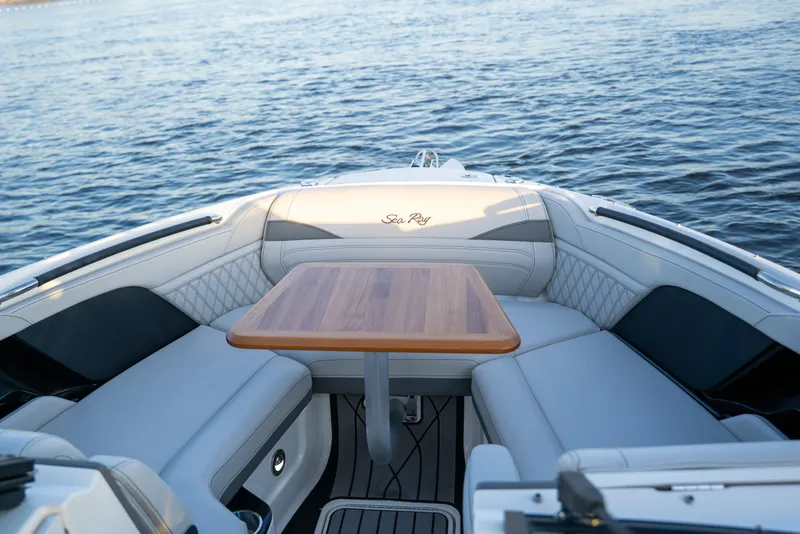 Slide: The Image of 2023 Sea Ray SLX 260 Outboard boat interior with seating and table on water. - 47