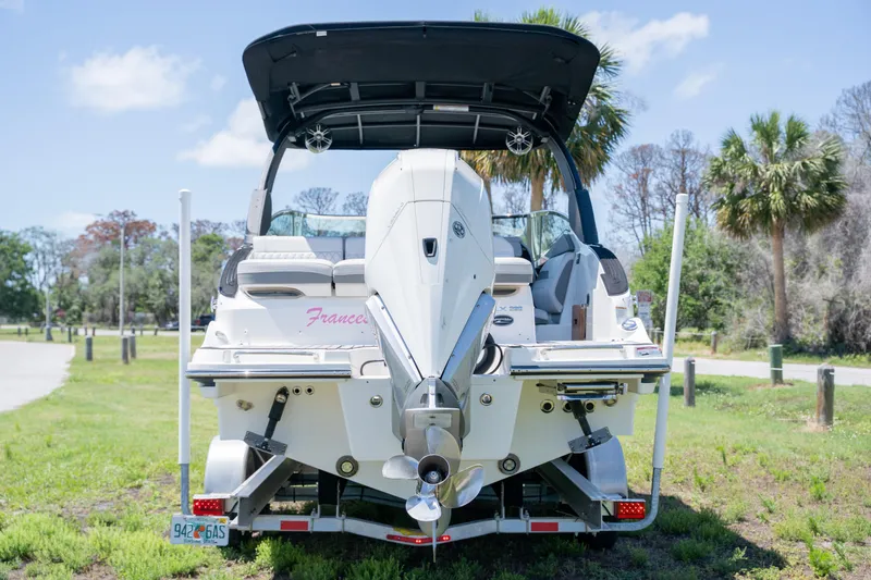 Slide: The Image of 2023 Sea Ray SLX 260 Outboard boat, rear view, parked on grass with palm trees. - 5