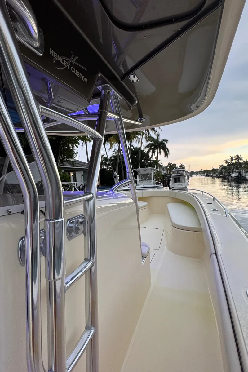 Slide: The Image of 2013 Bahama 41 boat with sleek design, docked by a serene waterfront at sunset. - 16