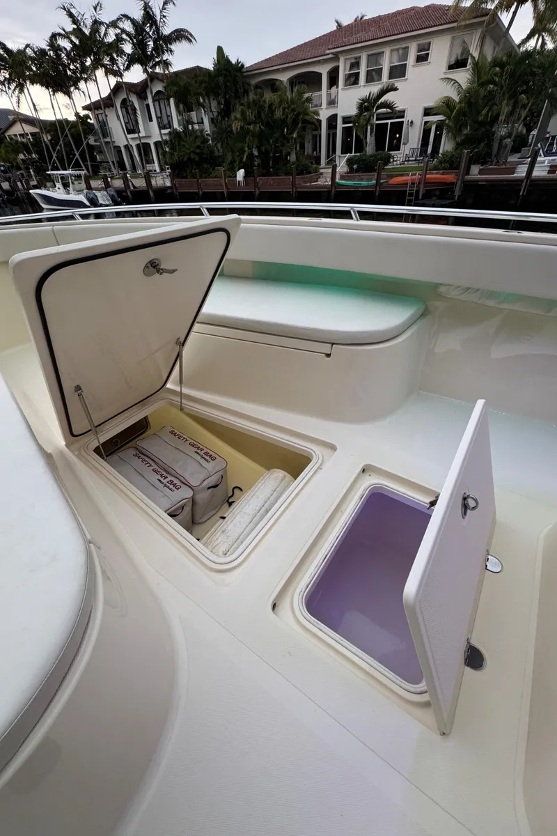 Slide: The Image of 2013 Bahama 41 boat with open storage compartments, docked near waterfront homes. - 18