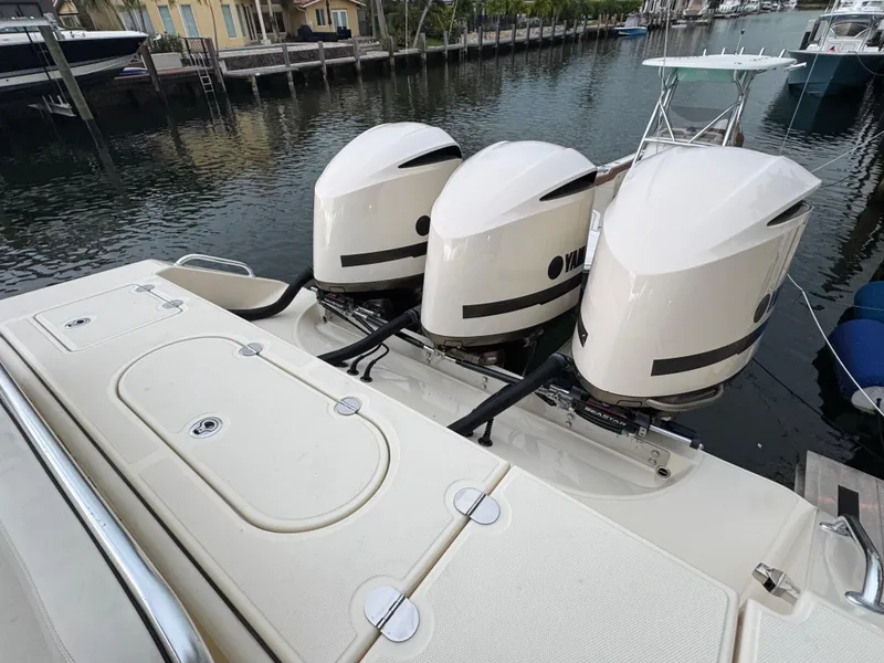 Slide: The Image of 2013 Bahama 41 boat with triple Yamaha outboard engines docked by the water. - 2