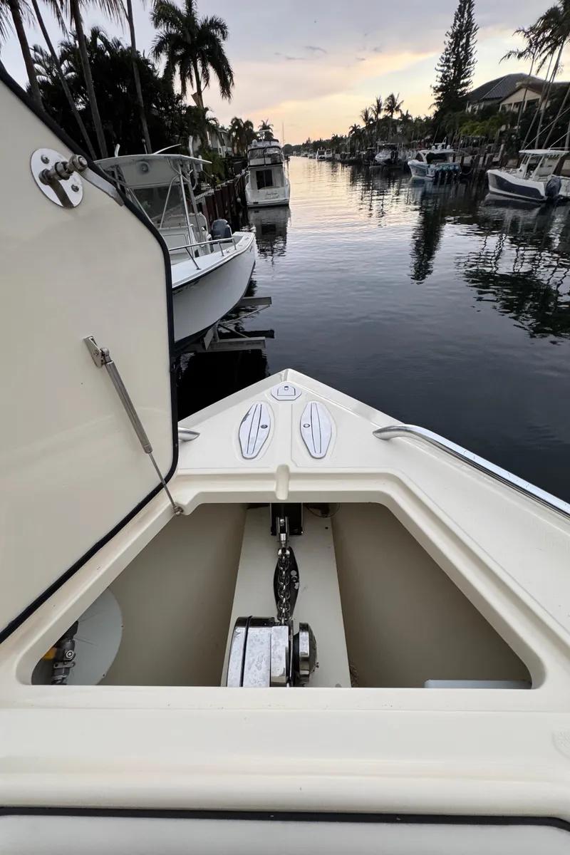 Slide: The Image of 2013 Bahama 41 boat with open anchor locker, docked in a serene marina. - 21