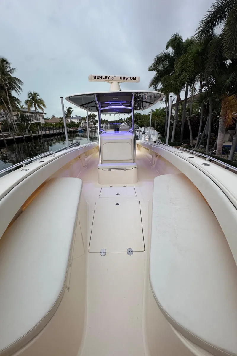Slide: The Image of 2013 Bahama 41 boat with spacious deck and custom features, docked near palm trees. - 22