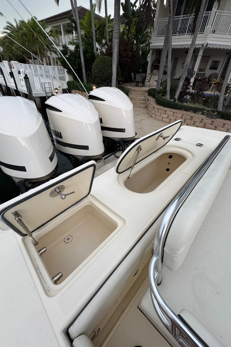 Slide: The Image of 2013 Bahama 41 boat with open storage compartments and triple outboard engines. - 3