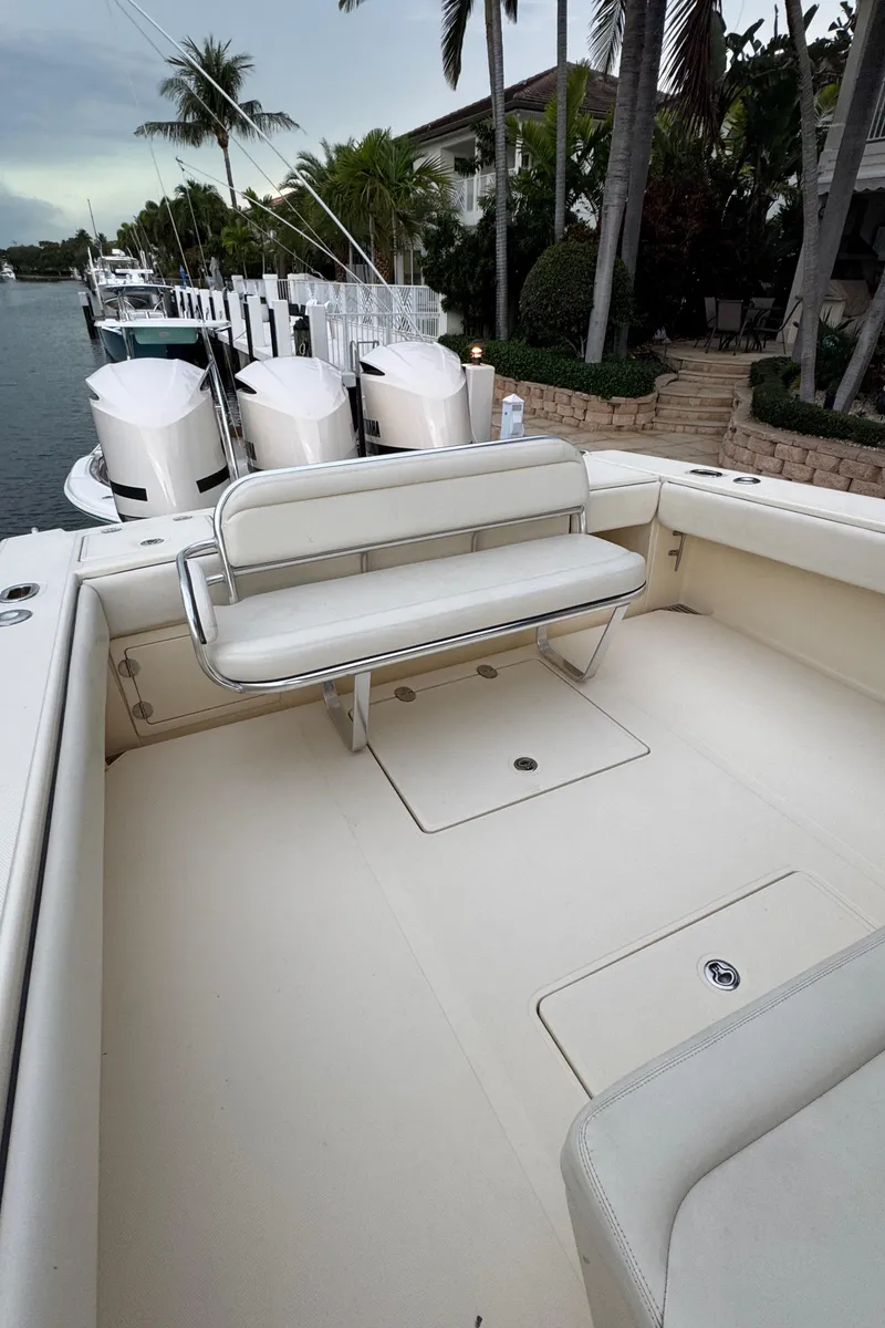 Slide: The Image of 2013 Bahama 41 boat with spacious deck and seating, docked near palm trees. - 6