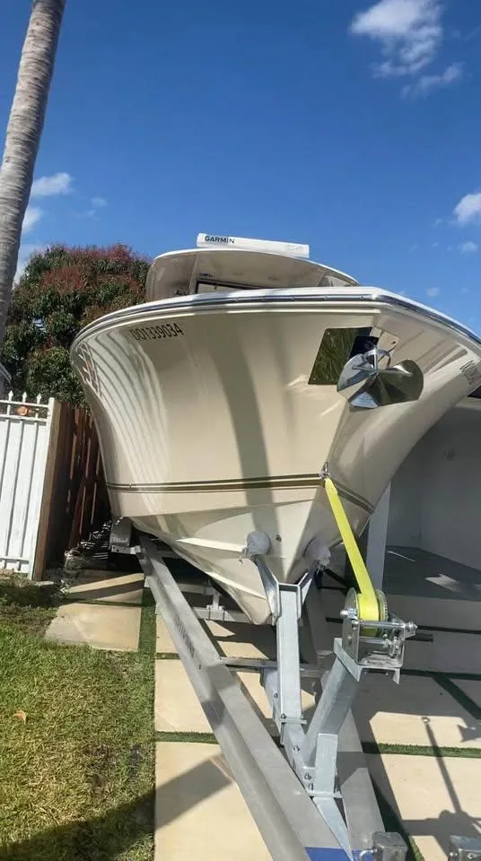 Slide: The Image of 2018 Cobia 344 Center Console boat on trailer under clear blue sky. - 10