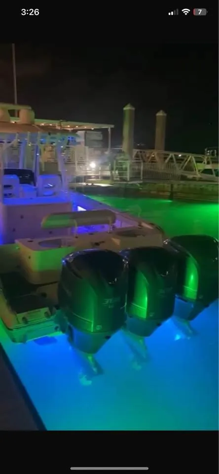 Slide: The Image of 2018 Cobia 344 Center Console boat with illuminated engines at night. - 9