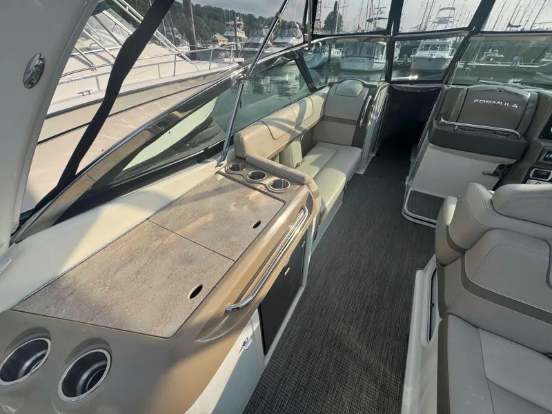 Slide: The Image of 2015 Formula 350 Crossover Bowrider interior with seating and dashboard, docked at marina. - 10