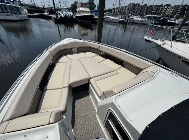 Slide: The Image of 2015 Formula 350 Crossover Bowrider with spacious seating at a marina. - 16