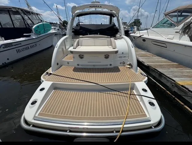Slide: The Image of 2015 Formula 350 Crossover Bowrider docked, showcasing spacious rear deck and seating. - 19