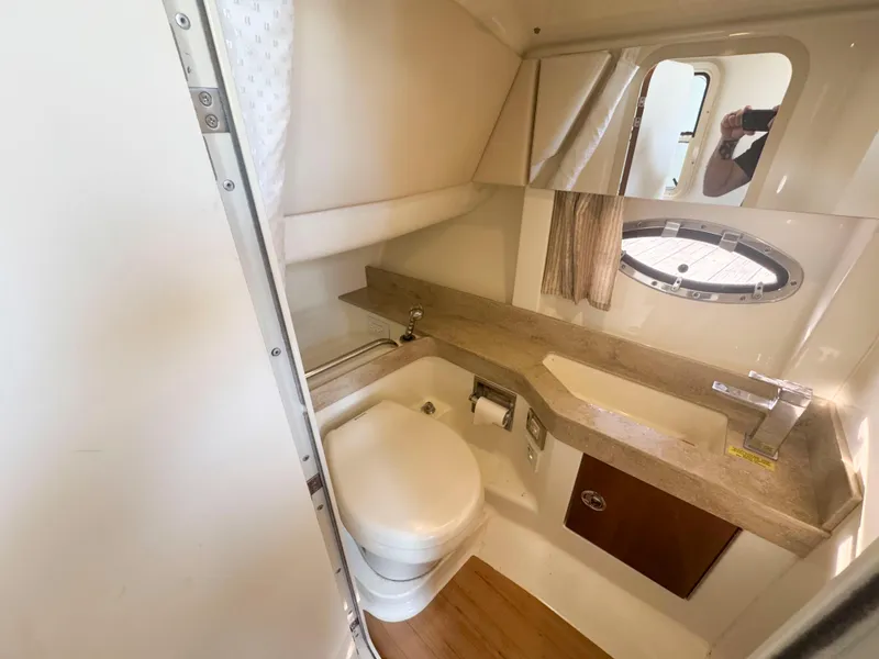 Slide: The Image of 2015 Formula 350 Crossover Bowrider bathroom with sink, toilet, and porthole window. - 26