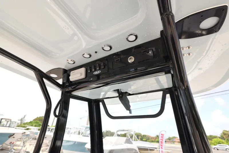 Slide: The Image of T-top console of 2025 Sea Hunt Ultra 245 SE boat with electronic controls and speakers. - 11