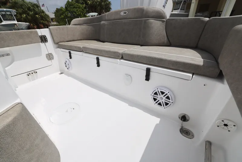 Slide: The Image of 2025 Sea Hunt Ultra 245 SE boat interior with cushioned seating and built-in speakers. - 16