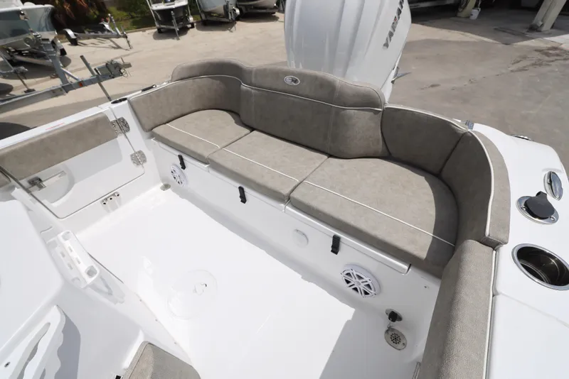 Slide: The Image of 2025 Sea Hunt Ultra 245 SE boat interior with cushioned seating and cup holders. - 8