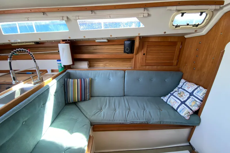 Slide: The Image of Cozy interior of 1992 Catalina 30 MkII sailboat with cushioned seating and wooden accents. - 14
