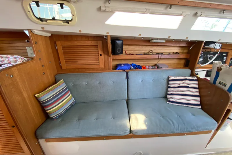 Slide: The Image of Interior of a 1992 Catalina 30 MkII sailboat with blue cushioned seating and striped pillows. - 21