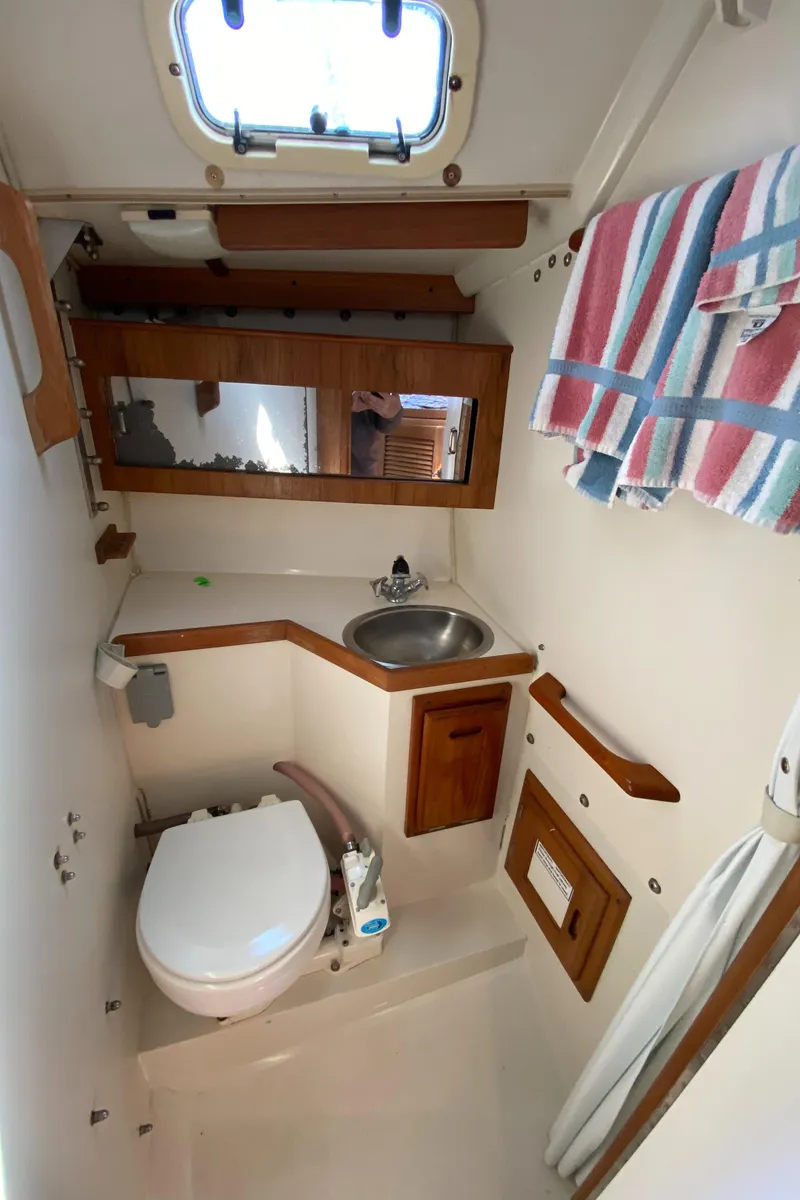 Slide: The Image of 1992 Catalina 30 MkII boat bathroom with sink, toilet, mirror, and striped towel. - 25