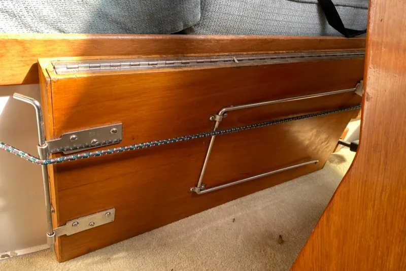 Slide: The Image of Wooden interior detail of a 1992 Catalina 30 MkII sailboat, featuring metal hinges and rope accents. - 30