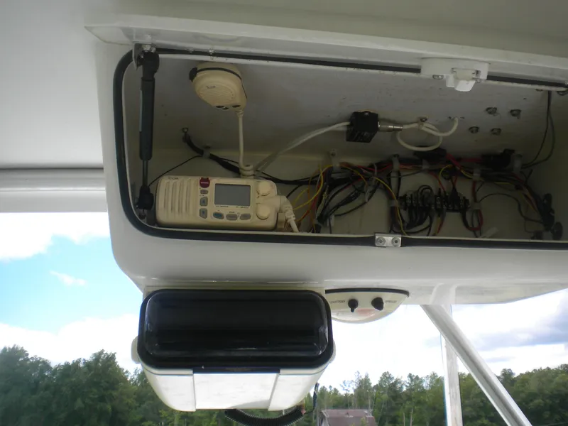 Slide: The Image of 2003 Pro-Line 23 Walk boat electronics compartment with wiring and communication equipment. - 10