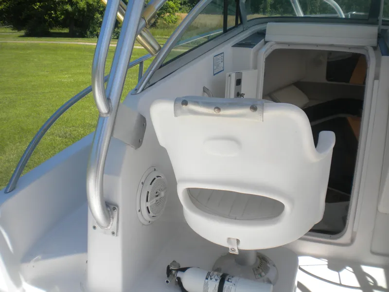 Slide: The Image of 2003 Pro-Line 23 Walk boat interior with white seating and safety equipment. - 14
