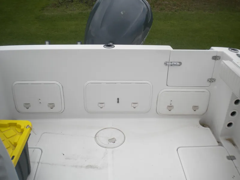 Slide: The Image of 2003 Pro-Line 23 Walk boat deck with storage compartments and engine view. - 16