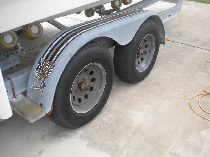 Slide: The Image of Trailer wheels for 2003 Pro-Line 23 Walk boat on concrete surface. - 29
