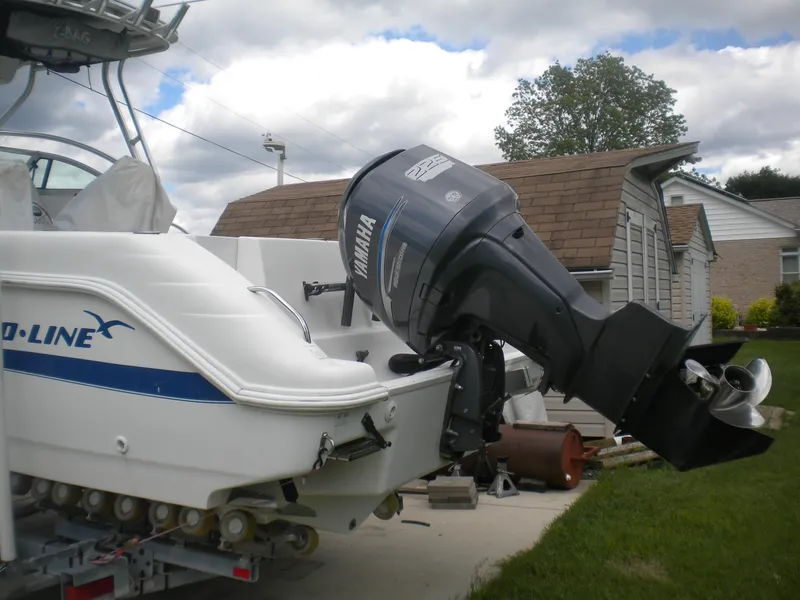Slide: The Image of 2003 Pro-Line 23 Walk boat with Yamaha outboard motor, parked near a house. - 5
