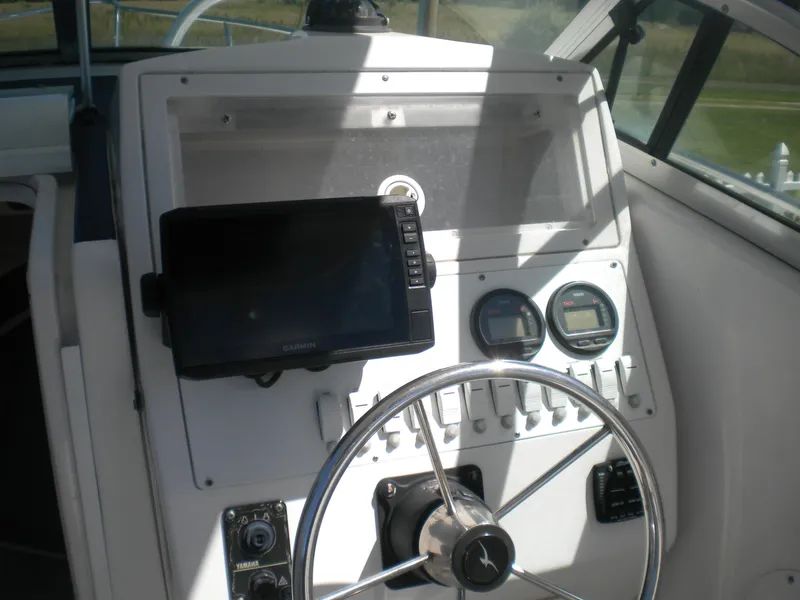 Slide: The Image of 2003 Pro-Line 23 Walk boat dashboard with steering wheel and navigation instruments. - 8