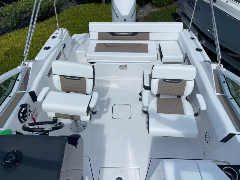 Slide: The Image of 2024 Blackfin 232DC boat interior with white and beige seating arrangement. - 18