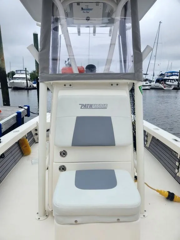Slide: The Image of 2023 Pathfinder 2300 HPS boat at marina, featuring center console and seating. - 11
