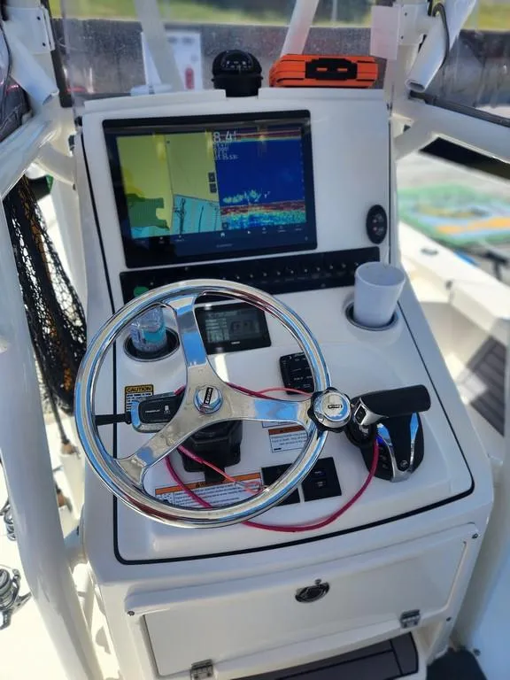 Slide: The Image of 2023 Pathfinder 2300 HPS boat console with steering wheel, navigation screen, and controls. - 15