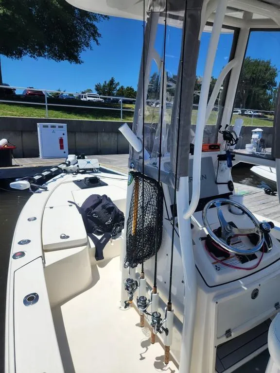 Slide: The Image of 2023 Pathfinder 2300 HPS boat with fishing gear, docked under clear blue sky. - 18