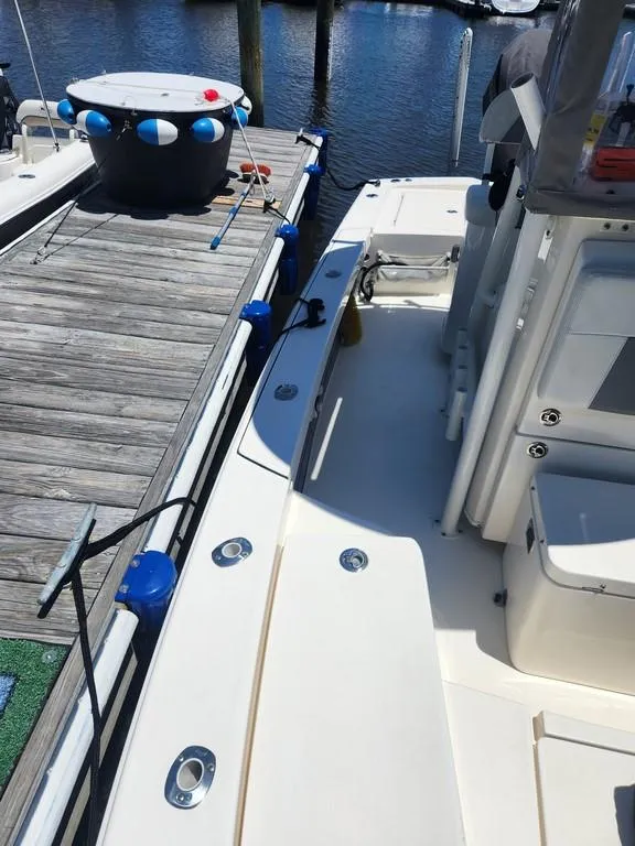 Slide: The Image of 2023 Pathfinder 2300 HPS boat docked at marina, showcasing deck and seating area. - 25