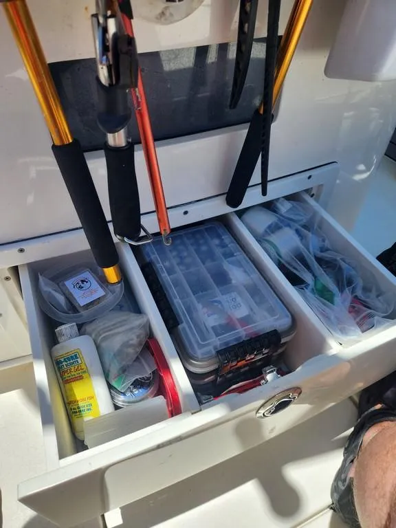 Slide: The Image of Fishing gear storage on 2023 Pathfinder 2300 HPS boat, featuring organized tackle boxes and equipment. - 31