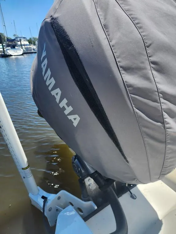 Slide: The Image of Outboard motor with Yamaha cover on 2023 Pathfinder 2300 HPS boat, docked by the water. - 32
