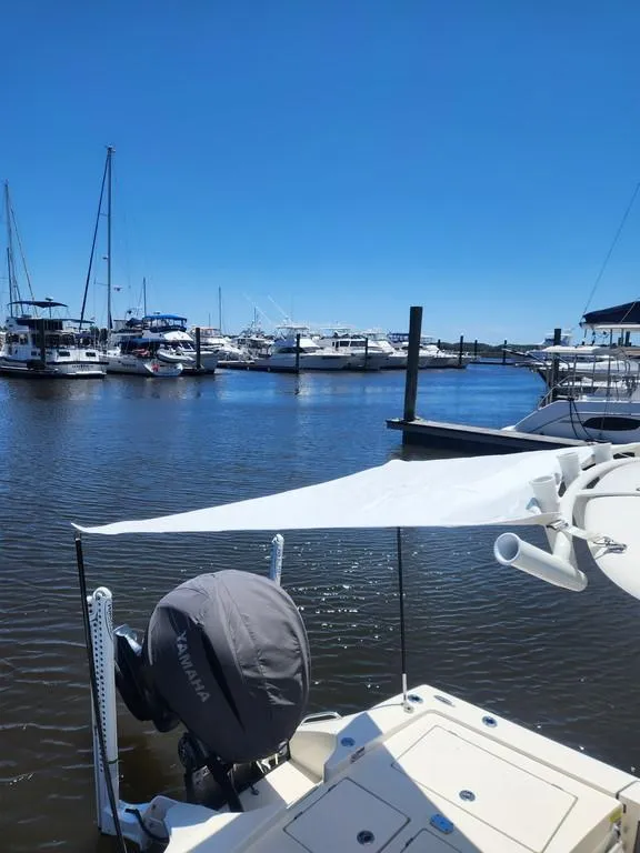 Slide: The Image of 2023 Pathfinder 2300 HPS boat docked in a marina under clear blue skies. - 8