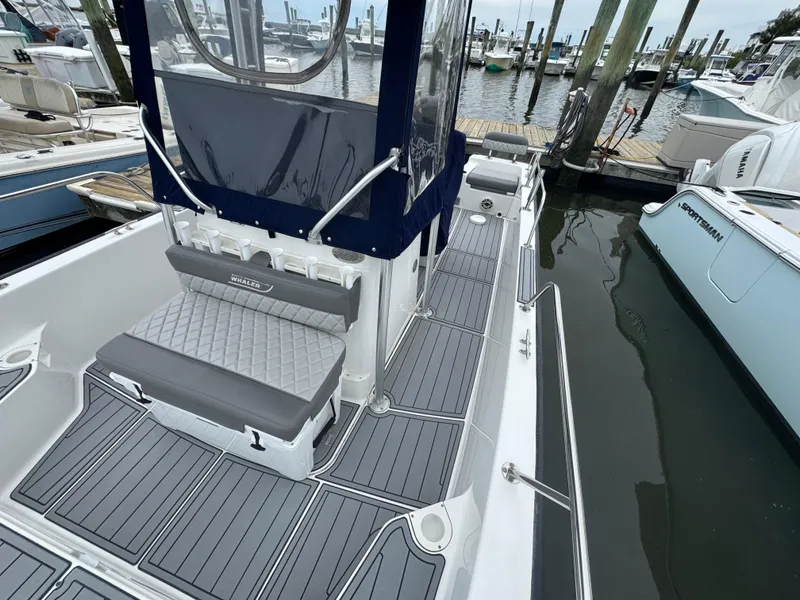 Slide: The Image of 2013 Boston Whaler 210 Montauk boat docked, featuring sleek seating and modern design. - 15