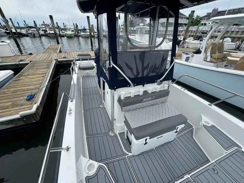 Slide: The Image of 2013 Boston Whaler 210 Montauk boat docked at marina with seating and canopy. - 16