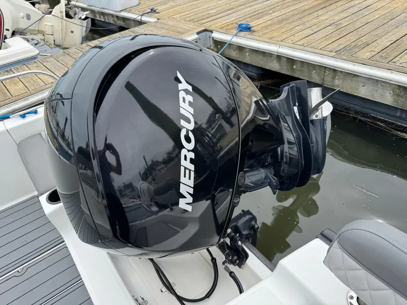 Slide: The Image of Mercury outboard motor on 2013 Boston Whaler 210 Montauk, docked by wooden pier. - 18