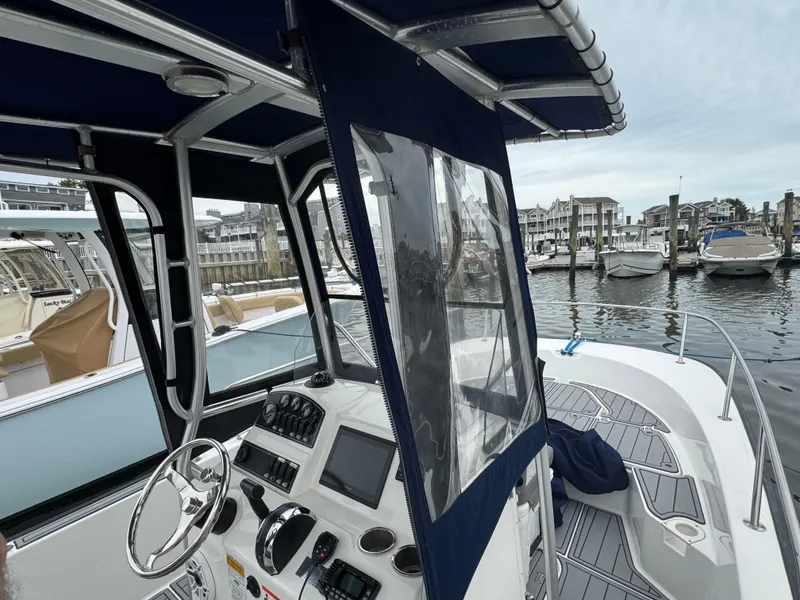 Slide: The Image of 2013 Boston Whaler 210 Montauk boat docked at marina, featuring helm and canopy. - 20