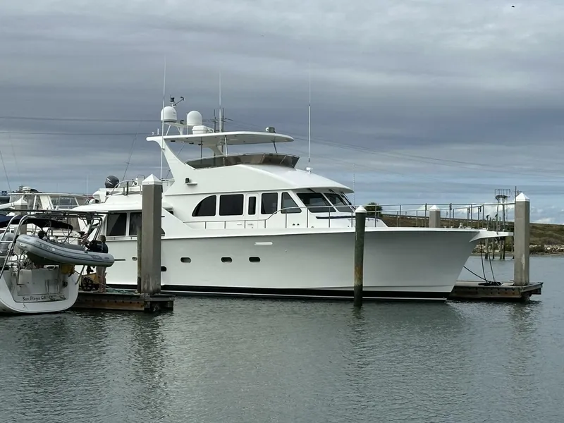 The Image of 2004 Cheoy Lee 72 yacht docked at marina under cloudy sky. - 1