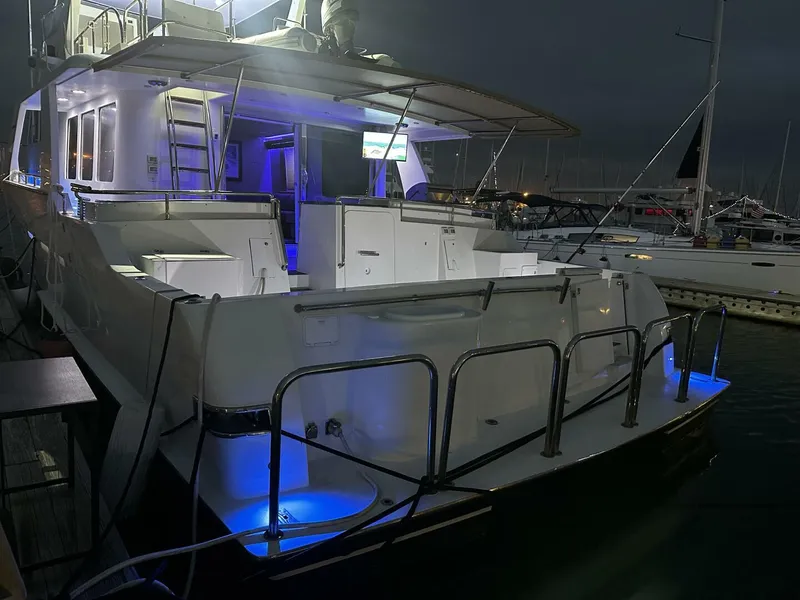 Slide: The Image of 2004 Cheoy Lee 72 yacht docked at night with blue underwater lights. - 13